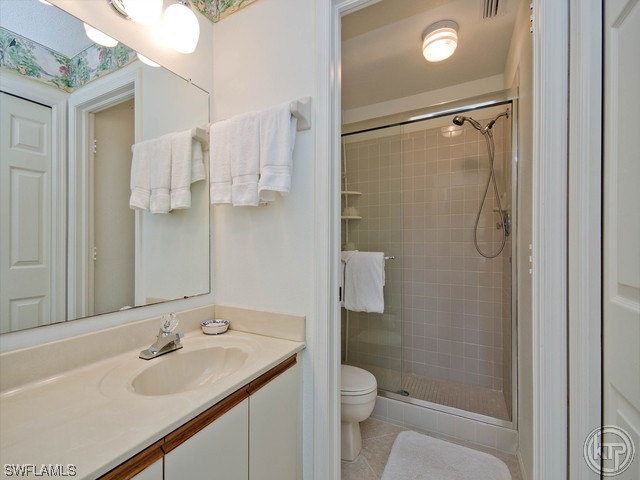 4580 Andover Way Naples, FL 34112 - Photo 9 of 12 a bathroom with a granite countertop sink toilet and shower