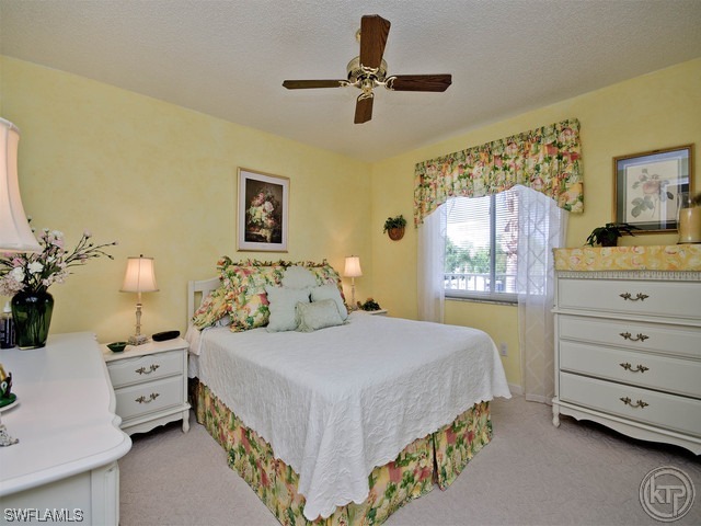 4580 Andover Way Naples, FL 34112 - Photo 10 of 12 a bedroom with a bed and a dresser in it