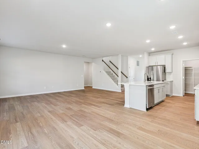 a living room with furniture a flat screen tv and kitchen view