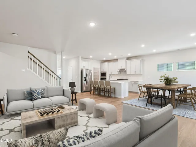 a kitchen with stainless steel appliances granite countertop a table chairs sink refrigerator and cabinets