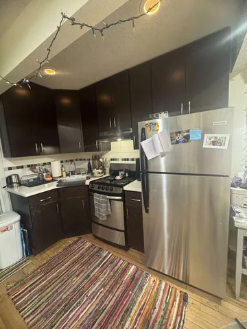 a kitchen with a refrigerator and a stove top oven