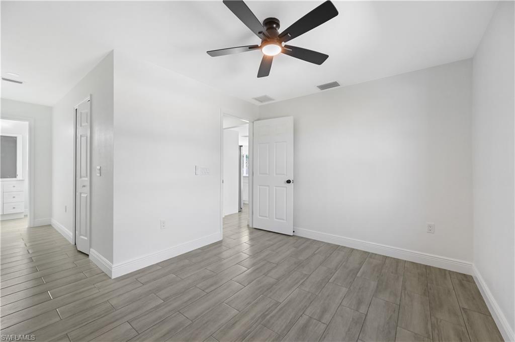 4448 18th Avenue Southwest Naples, FL 34116 - Photo 11 of 28 an empty room with wooden floor and a ceiling fan
