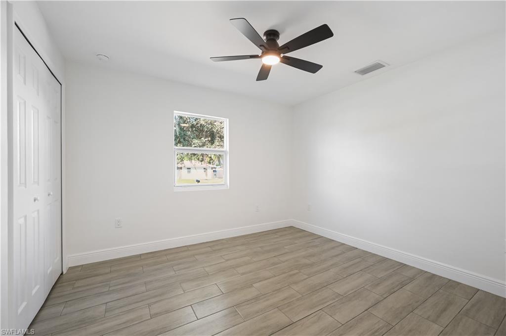 4448 18th Avenue Southwest Naples, FL 34116 - Photo 19 of 28 an empty room with wooden floor and windows