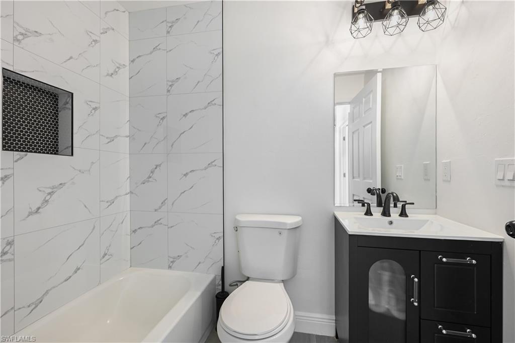 4448 18th Avenue Southwest Naples, FL 34116 - Photo 21 of 28 a bathroom with a sink vanity mirror and toilet