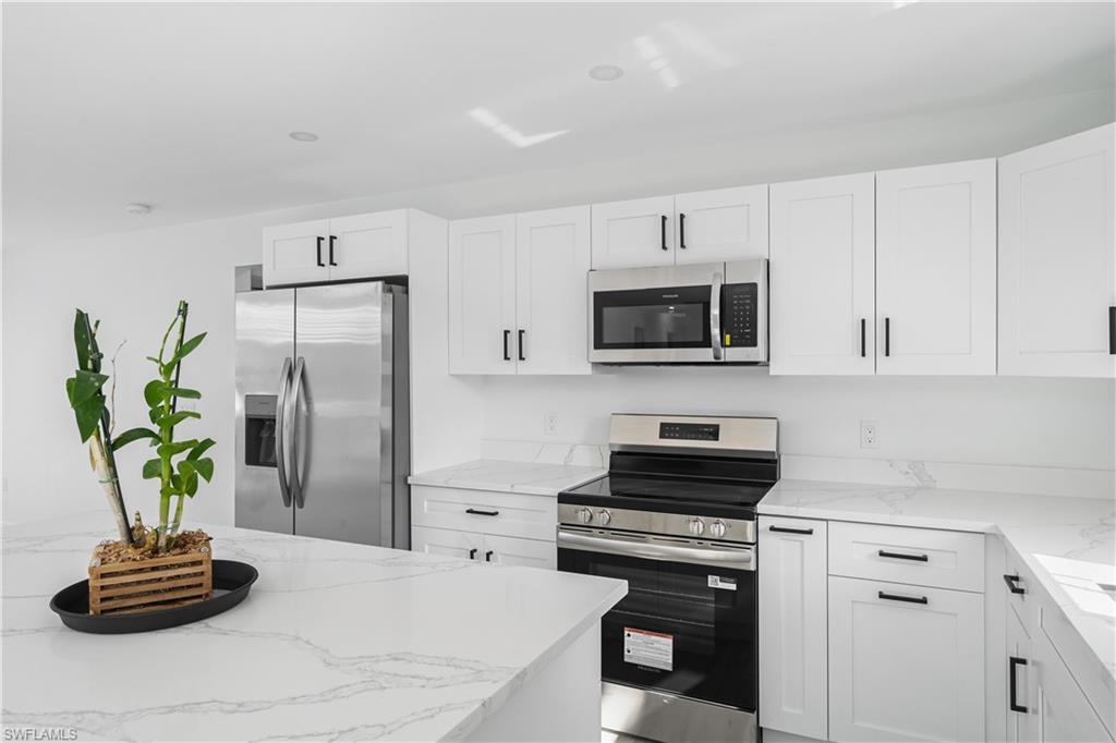 4448 18th Avenue Southwest Naples, FL 34116 - Photo 5 of 28 a kitchen with a refrigerator a stove and cabinets