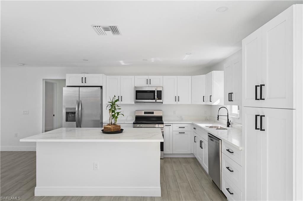 4448 18th Avenue Southwest Naples, FL 34116 - Photo 6 of 28 a kitchen with stainless steel appliances a sink dishwasher stove refrigerator and microwave
