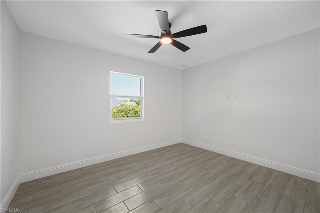 4448 18th Avenue Southwest Naples, FL 34116 - Photo 9 of 28 an empty room with wooden floor and window