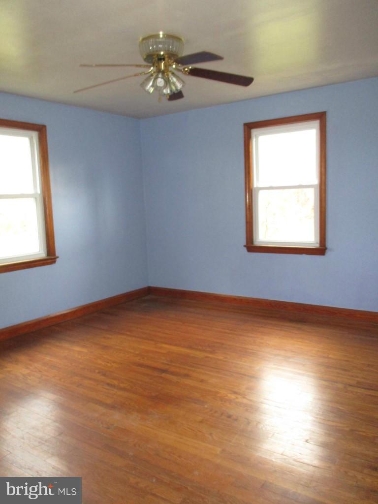 5716 Hilltop Road Baltimore, MD 21220 - Photo 3 of 12 a view of an empty room with a window and wooden floor