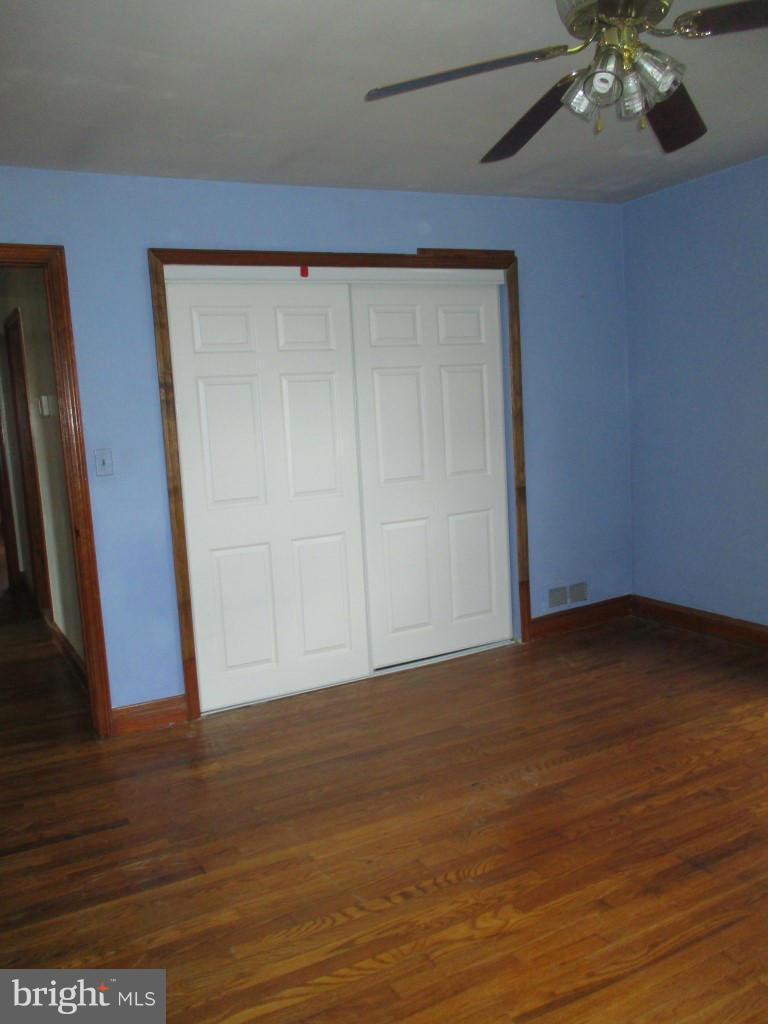 5716 Hilltop Road Baltimore, MD 21220 - Photo 4 of 12 a view of an empty room with wooden floor and a window