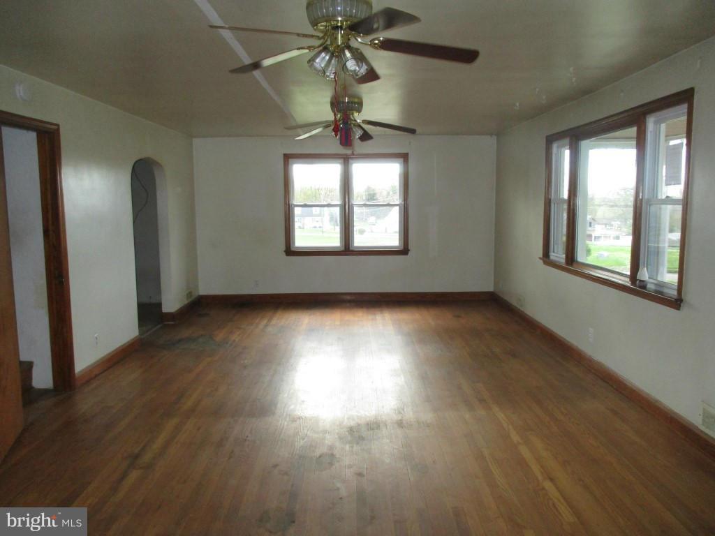 5716 Hilltop Road Baltimore, MD 21220 - Photo 5 of 12 a view of empty room with wooden floor and fan