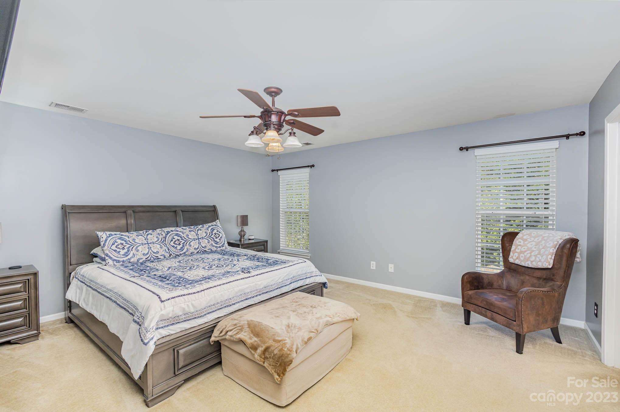 2379 Smith Cove Road Denver, NC 28037 - Photo 21 of 40 a bedroom with a bed and a chandelier