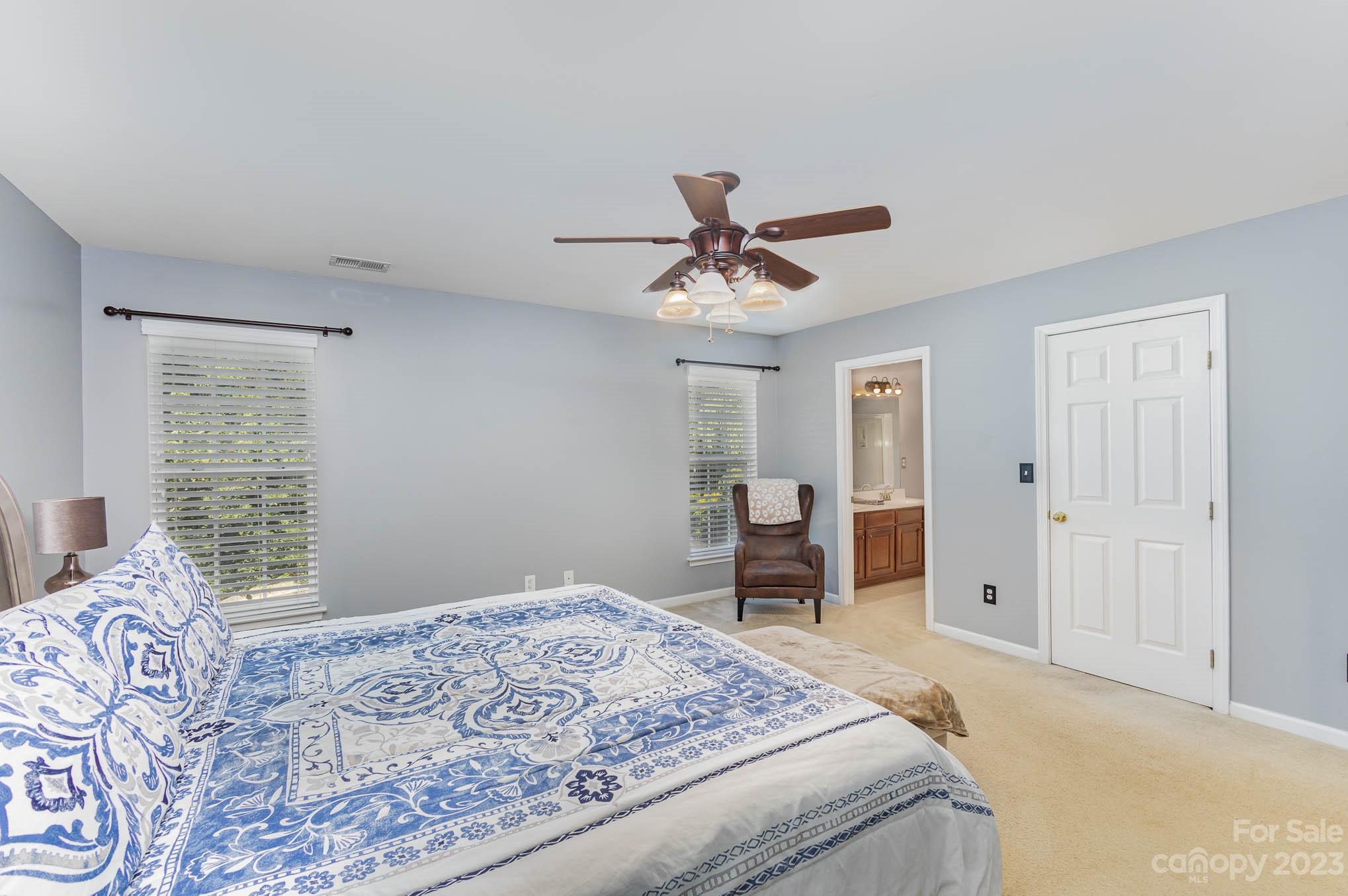2379 Smith Cove Road Denver, NC 28037 - Photo 22 of 40 a bedroom with a large bed and a chandelier