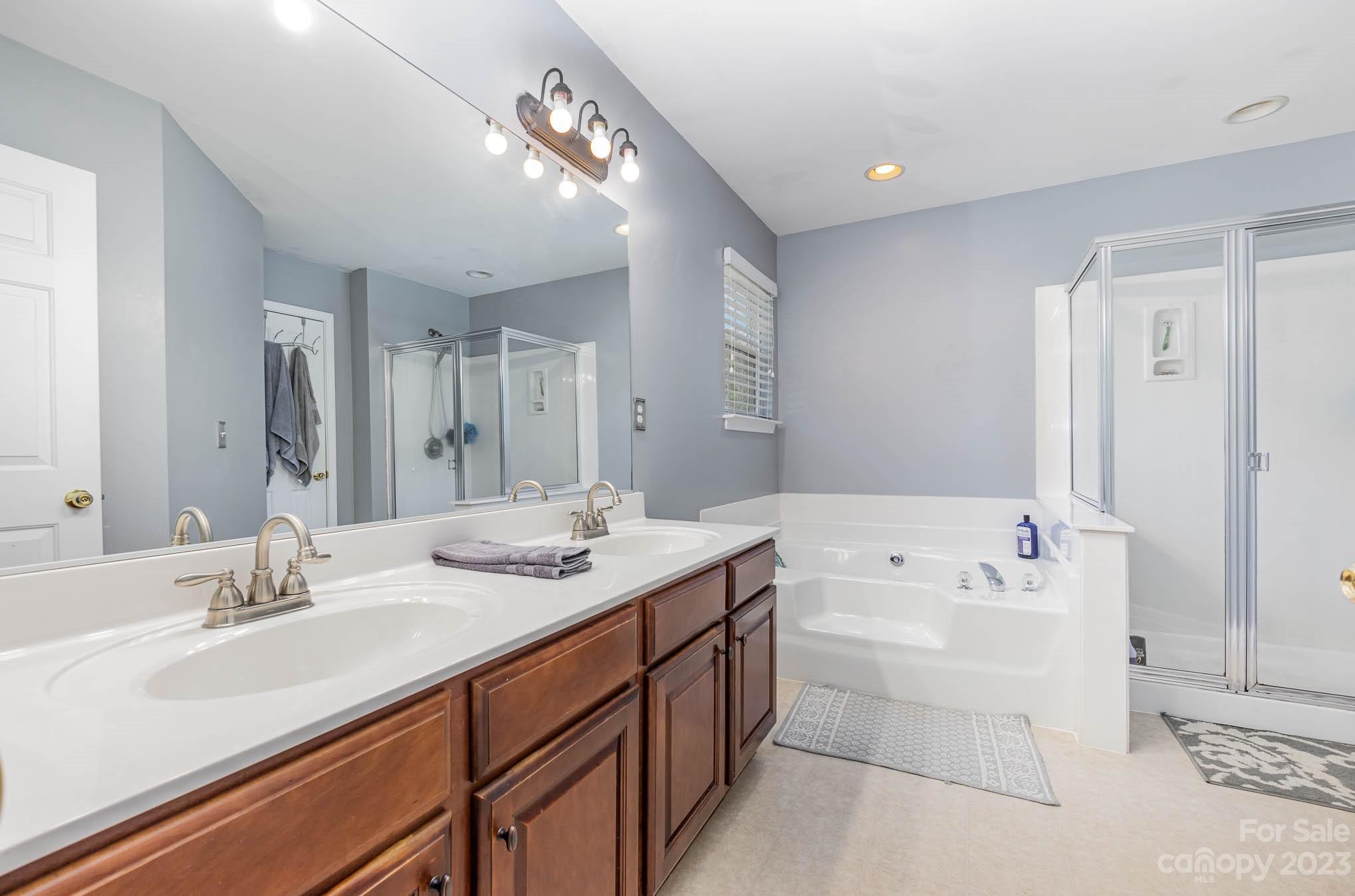 2379 Smith Cove Road Denver, NC 28037 - Photo 25 of 40 a bathroom with a sink double vanity granite tub shower and a mirror