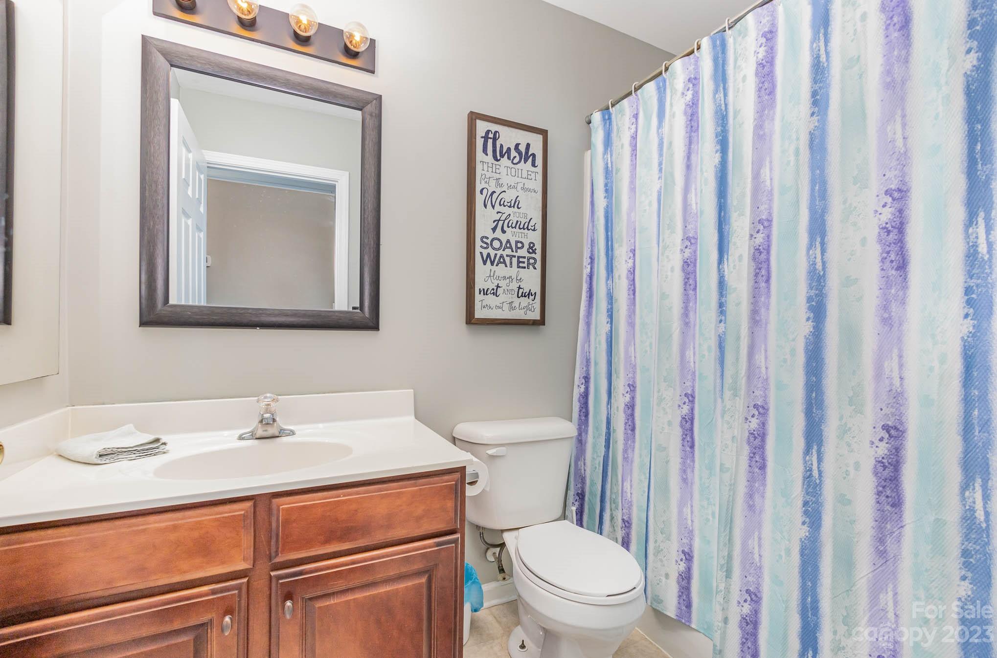 2379 Smith Cove Road Denver, NC 28037 - Photo 30 of 40 a bathroom with a sink a toilet and shower curtain