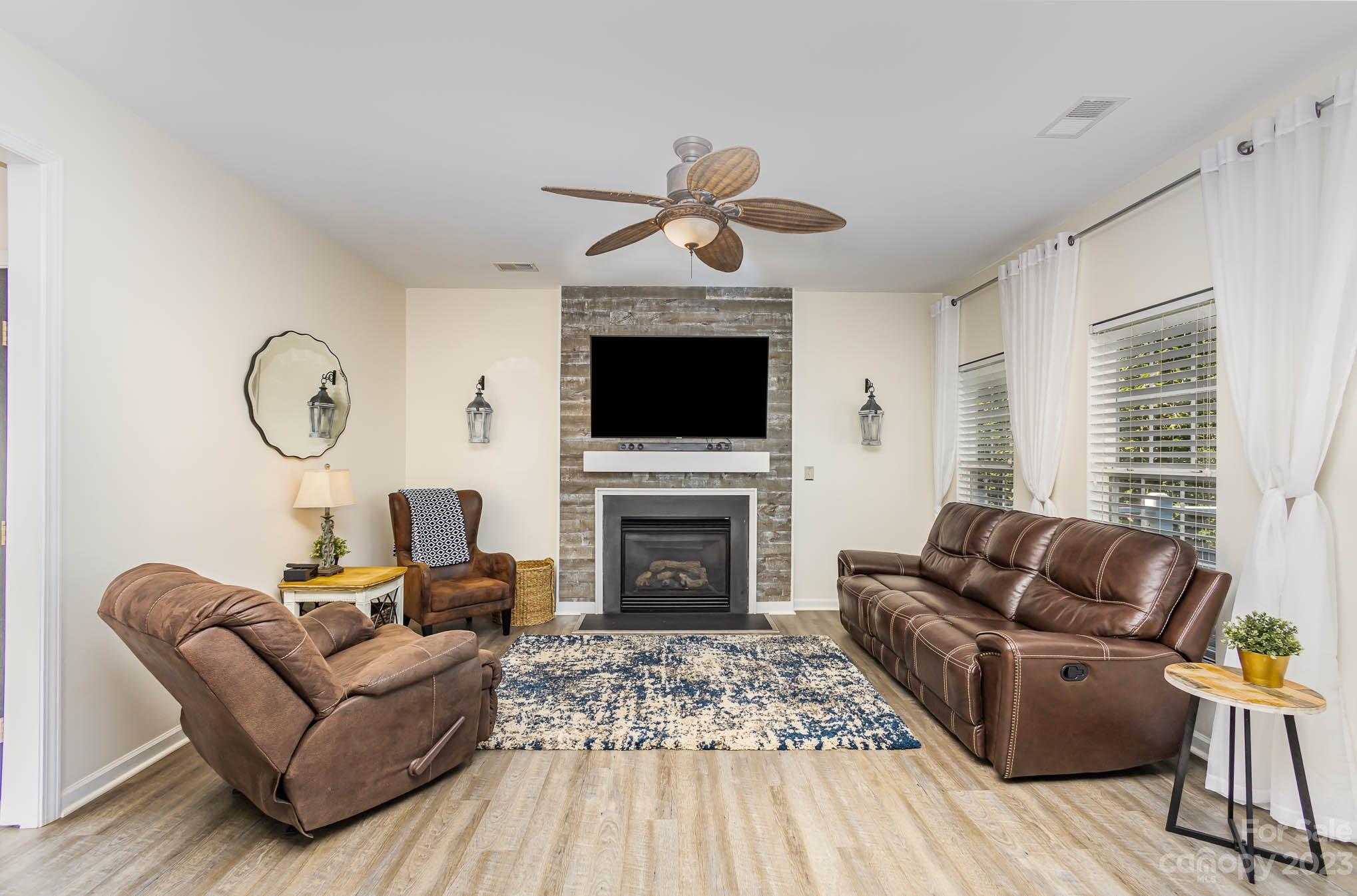 2379 Smith Cove Road Denver, NC 28037 - Photo 4 of 40 a living room with furniture a fireplace and a flat screen tv
