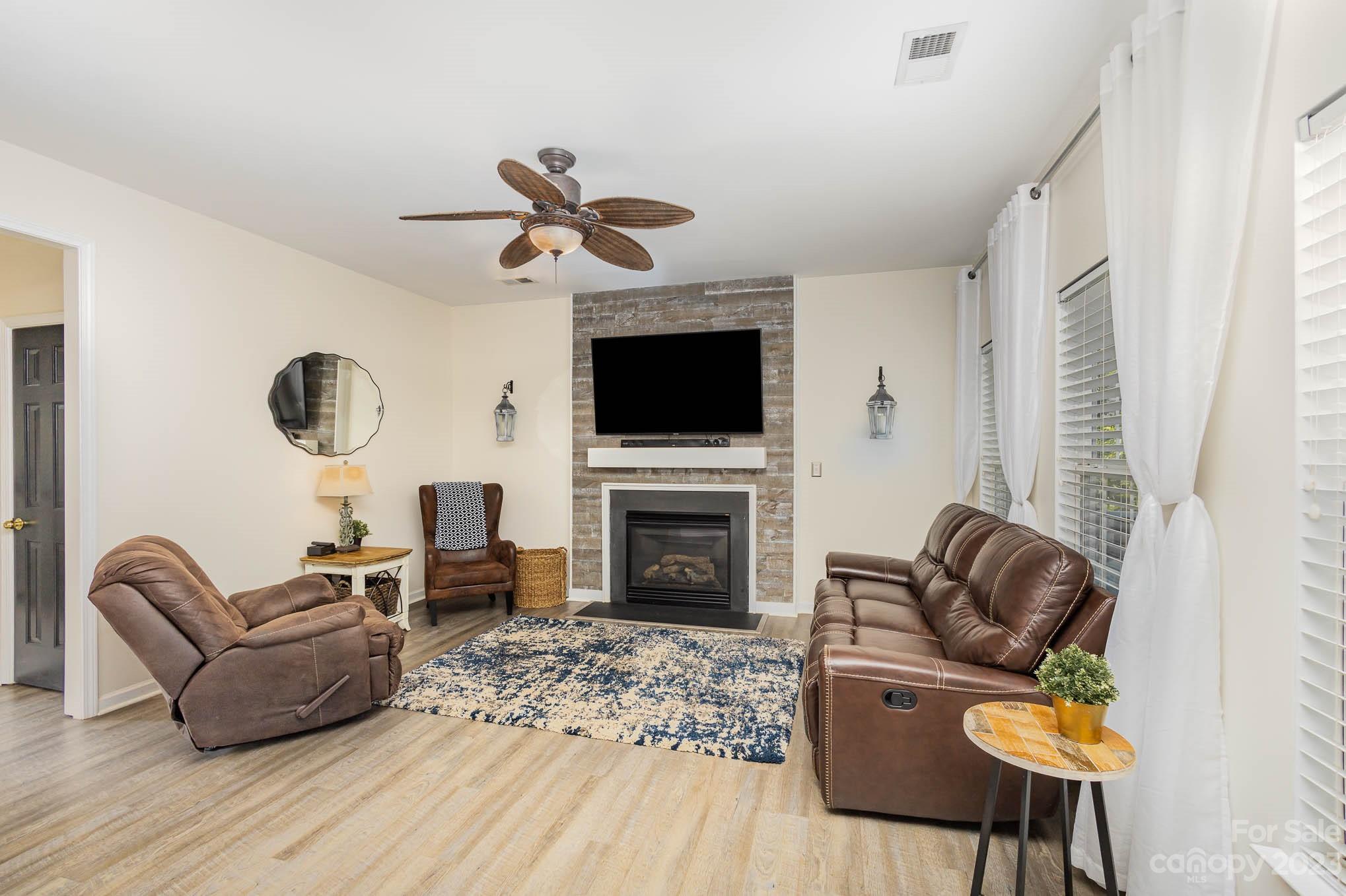 2379 Smith Cove Road Denver, NC 28037 - Photo 5 of 40 a living room with furniture a fireplace and a flat screen tv
