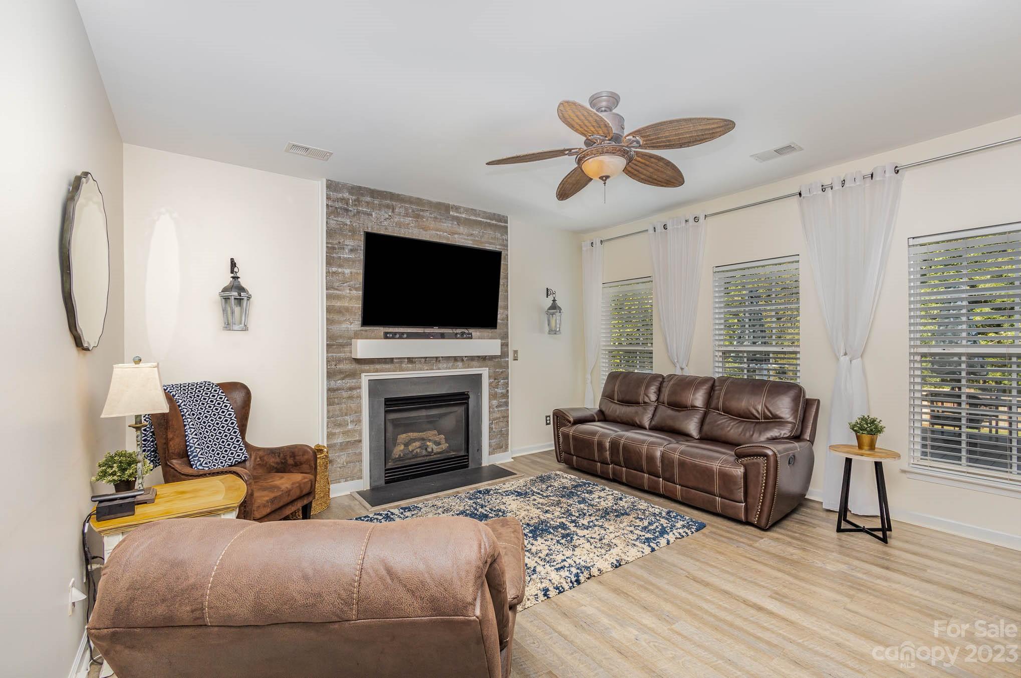 2379 Smith Cove Road Denver, NC 28037 - Photo 6 of 40 a living room with furniture a flat screen tv and a fireplace