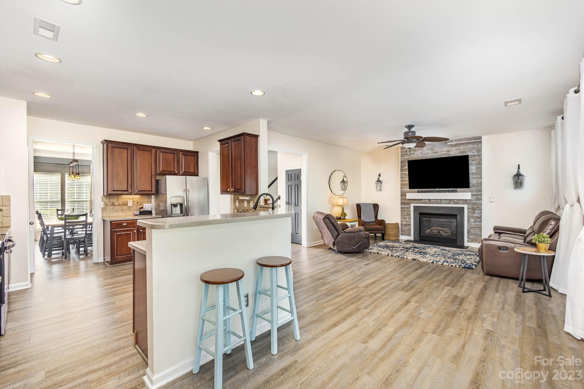 2379 Smith Cove Road Denver, NC 28037 - Photo 8 of 40 a living room with furniture a fireplace a flat screen tv and kitchen view