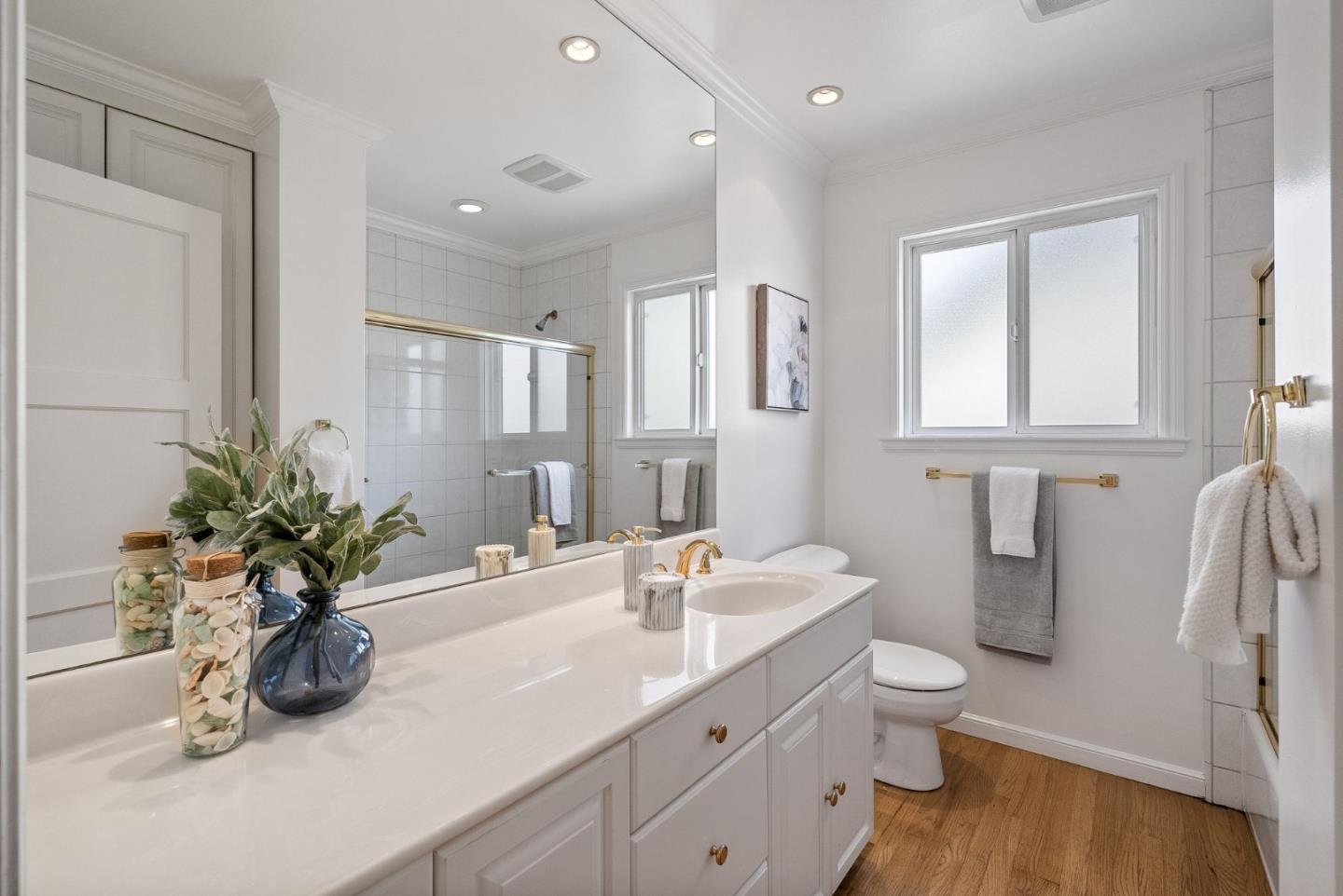 1127 Eastmoor Road Burlingame, CA 94010 - Photo 45 of 58 a bathroom with a granite countertop sink a toilet and a mirror