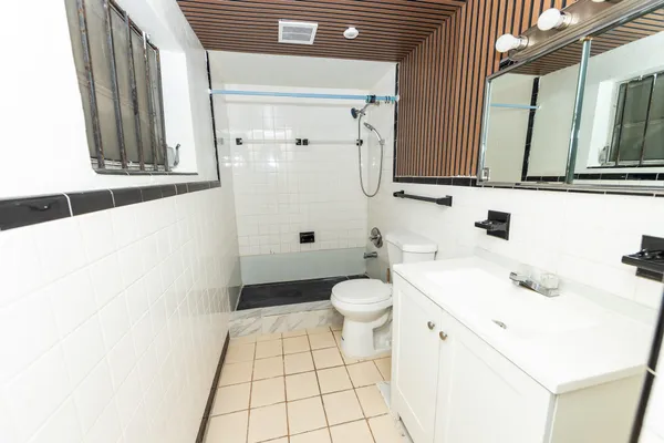 a bathroom with a sink a toilet and a mirror