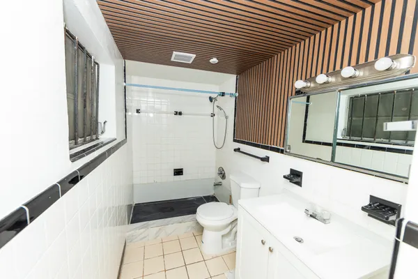 a bathroom with a sink a toilet and shower