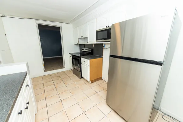 a kitchen with a refrigerator a stove top oven and a counter space