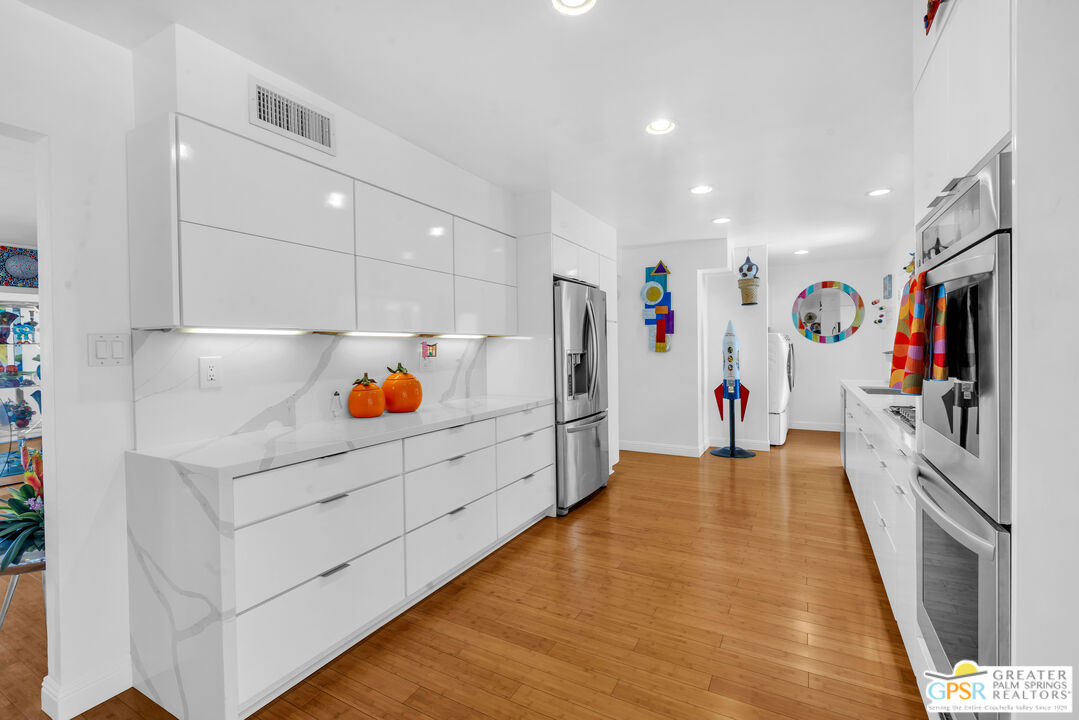 68401 Rodeo Road Cathedral City, CA 92234 - Photo 13 of 46 a hallway with cabinets and wooden floor