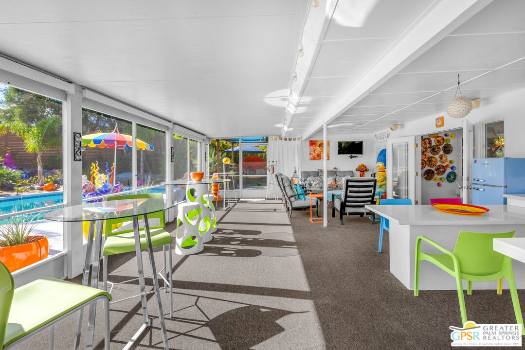 68401 Rodeo Road Cathedral City, CA 92234 - Photo 28 of 46 a room with lots of white furniture a chandelier and a dining table