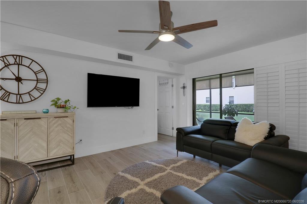 1001 Keystone Drive, Unit A Jupiter, FL 33458 - Photo 14 of 30 a living room with furniture a flat screen tv and a large window
