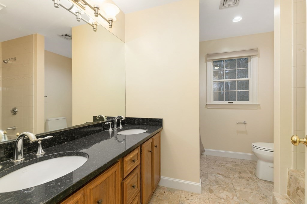 1 Sutton Place Weston, MA 02493 - Photo 17 of 33 a bathroom with a granite countertop sink a toilet and a mirror