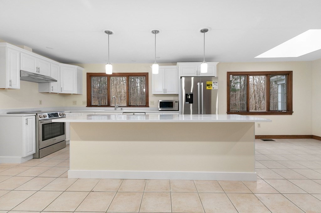 1 Sutton Place Weston, MA 02493 - Photo 5 of 33 a large kitchen with granite countertop a stove top oven a sink a counter space and cabinets