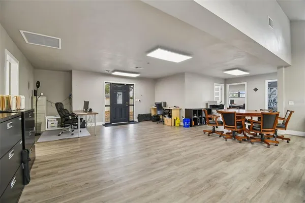 a view of a workspace with furniture and wooden floor