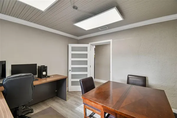 a view of a workspace with furniture and a gym machine