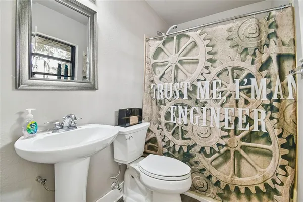 a bathroom with a toilet sink and mirror