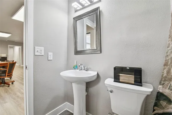 a view of a hallway with wooden floor and a living room