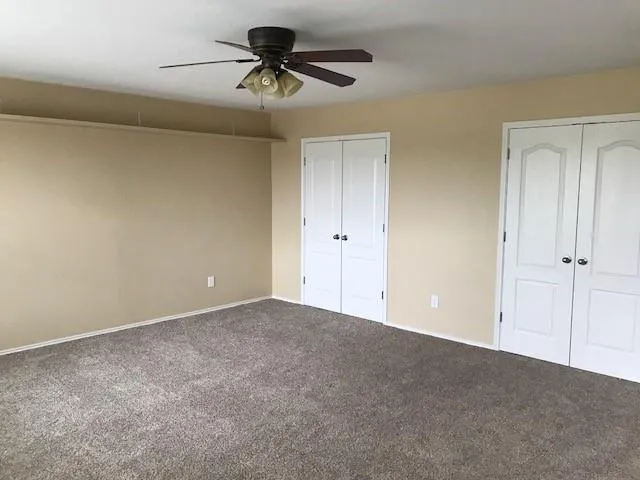 a view of room with a ceiling fan and a ceiling fan
