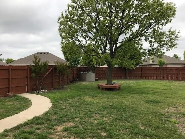 a view of a backyard with table and chairs and wooden fence