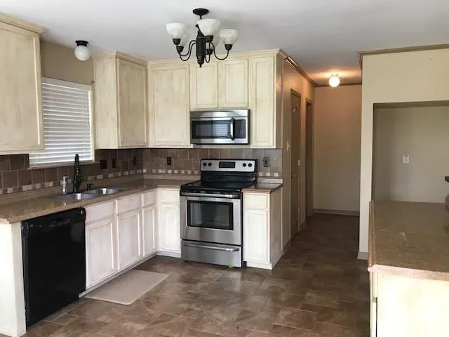 a kitchen with stainless steel appliances granite countertop a stove a sink and a microwave