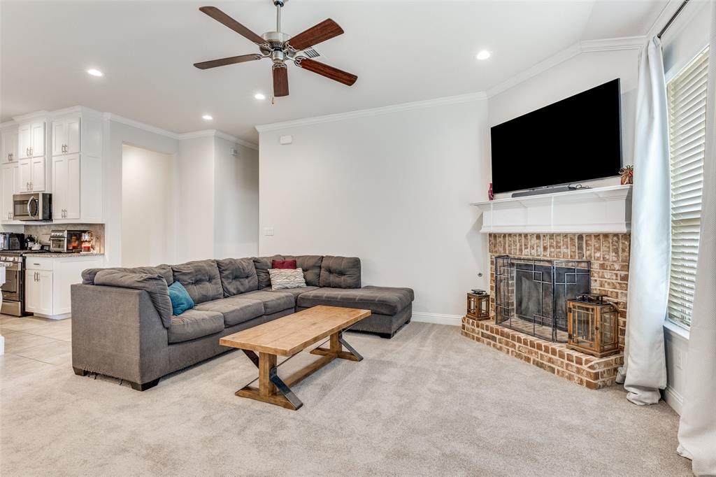 1173 Roping Reins Way Fort Worth, TX 76052 - Photo 11 of 24 Living area with light carpet, ceiling fan, crown molding, recessed lighting, and a fireplace