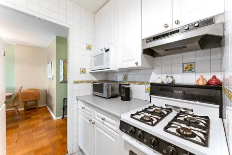 a kitchen with stove and cabinets