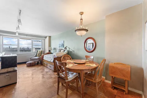 a living room with furniture a large window and a table