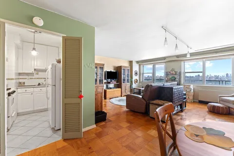 a living room with furniture and a view of kitchen