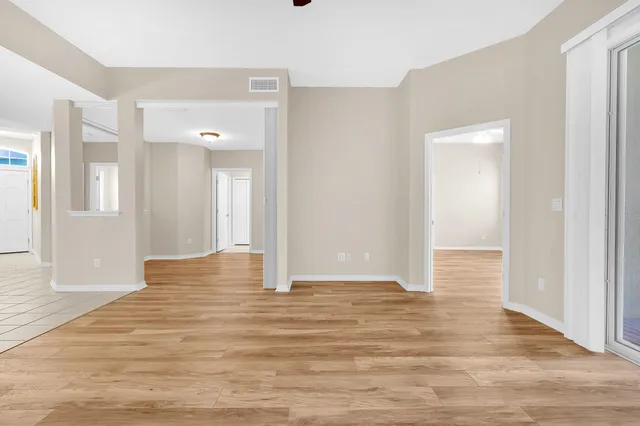 a view of an empty room with wooden floor
