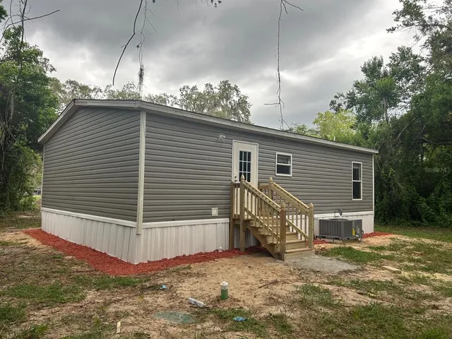 a view of house with backyard and trees