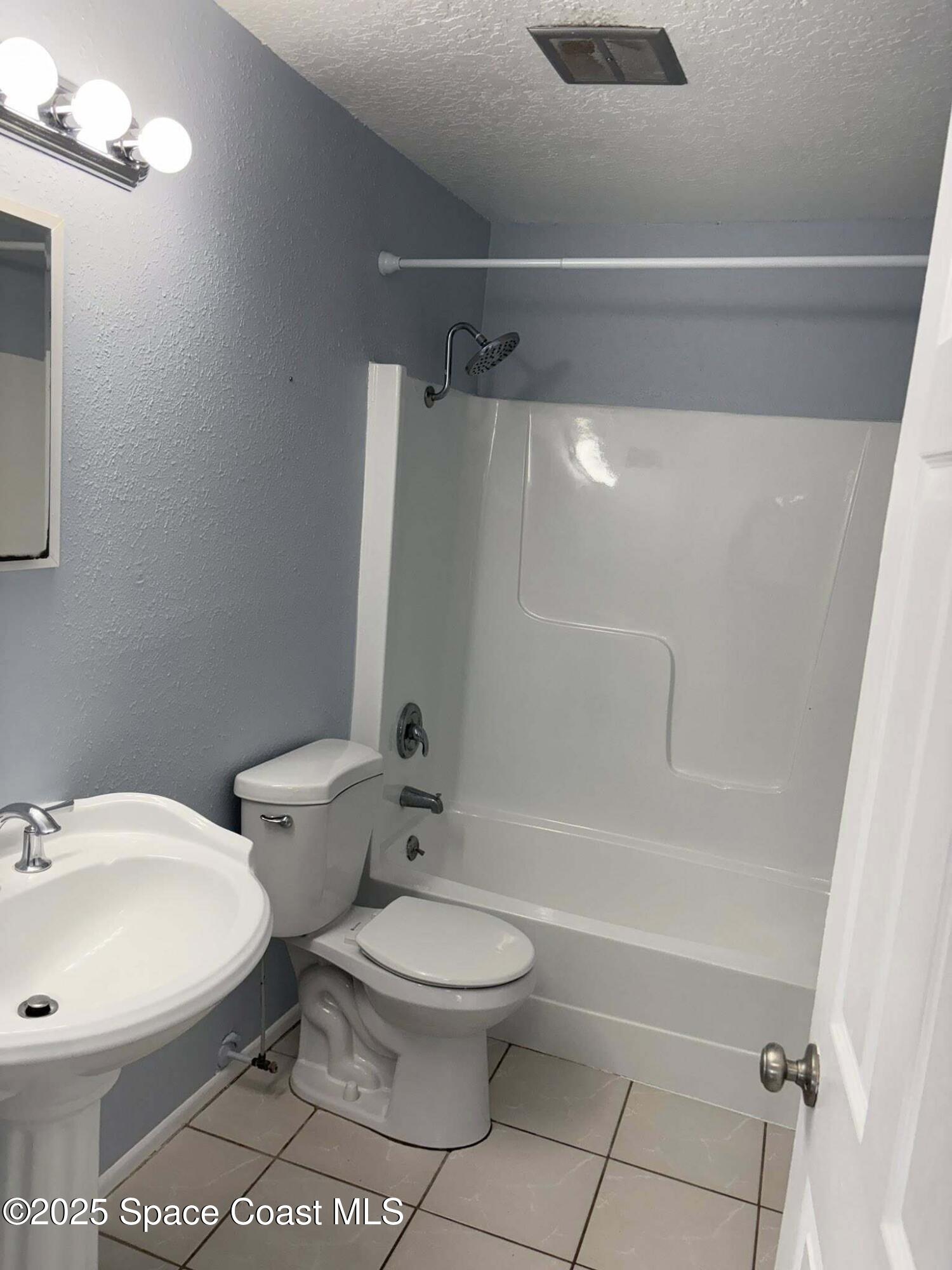 331 South Brevard Avenue, Unit B Cocoa Beach, FL 32931 - Photo 11 of 23 a white toilet sitting next to a bath tub