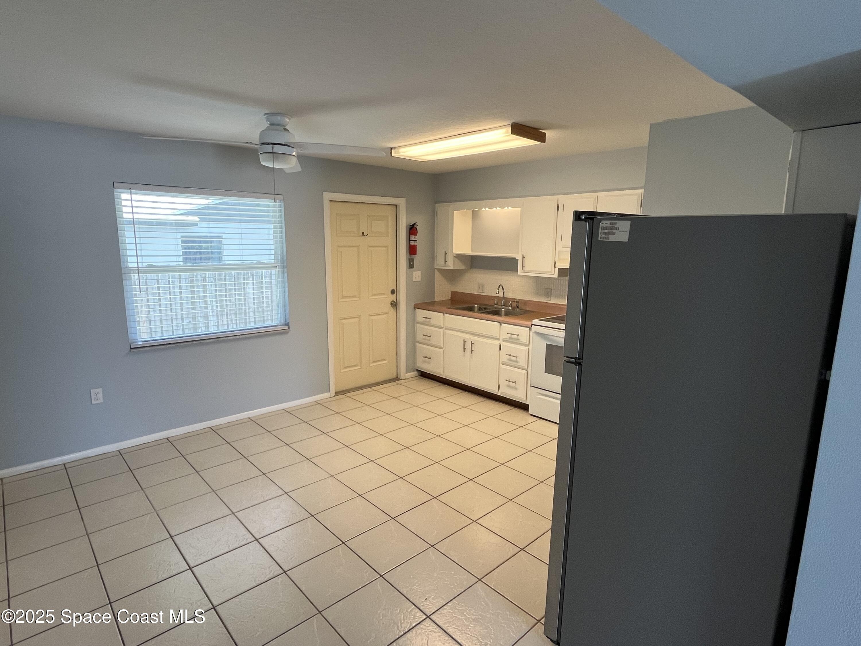 331 South Brevard Avenue, Unit B Cocoa Beach, FL 32931 - Photo 7 of 23 a kitchen with stainless steel appliances a refrigerator and a stove top oven