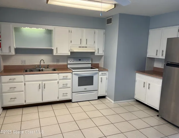 a kitchen with cabinets stainless steel appliances and a counter space