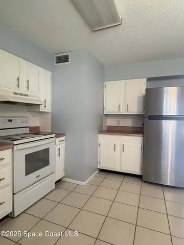 a kitchen with a refrigerator sink and cabinets