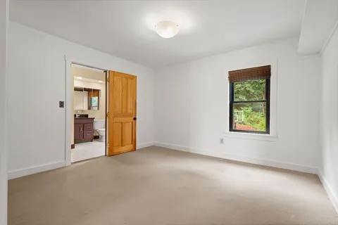 an empty room with windows and closet