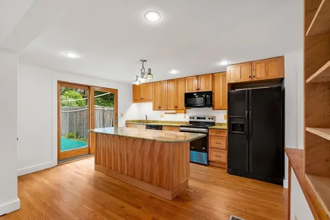 a kitchen with stainless steel appliances granite countertop a refrigerator stove top oven and sink